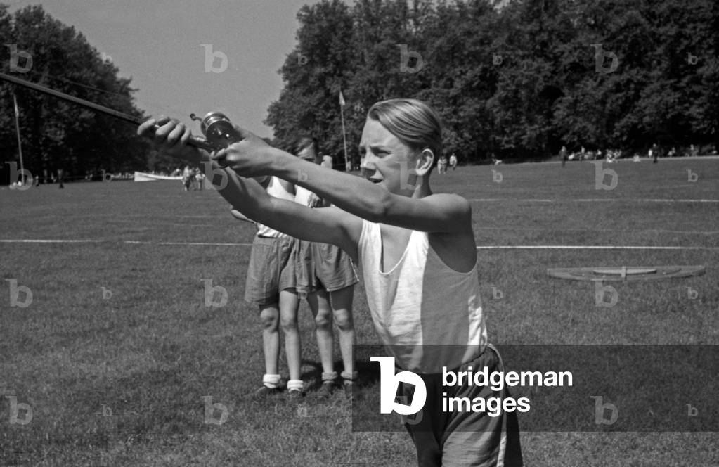 A boy doing a fry run in angling at a lawn, Germany 1930s (b/w photo)