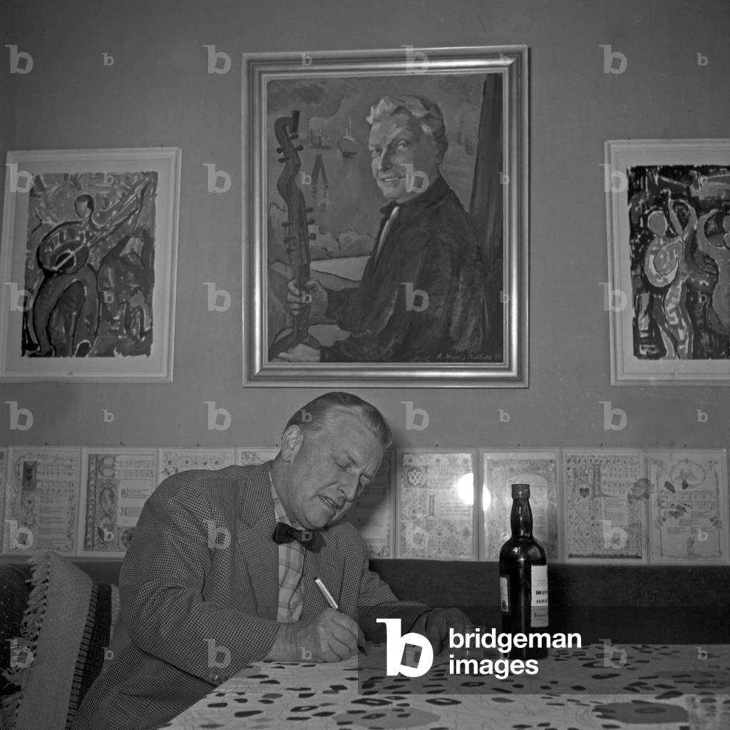 German singer, lutenist and composer Richard Germer composing while having a drink, Germany 1950s