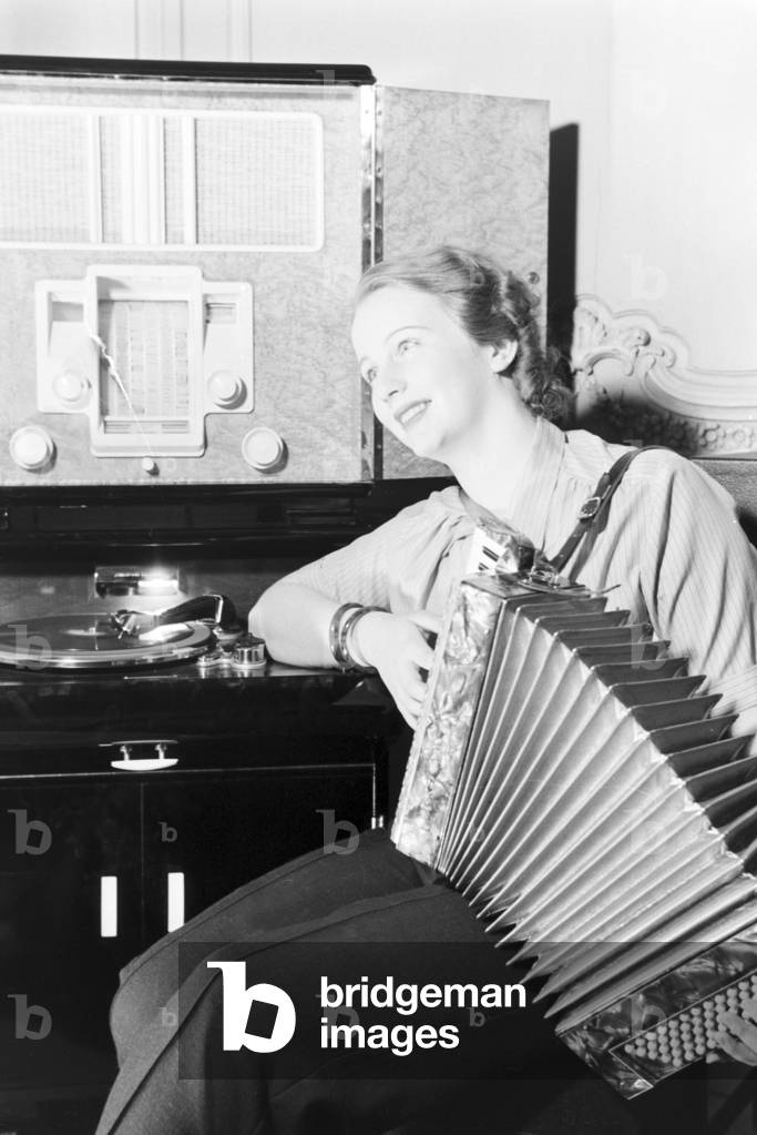 Family music: the princess of carnival in Mainz 1938, on the occasion of the 100th anniversary of the leading local carnival association, at home with her accordion in Nieder-Olm (b/w photo)