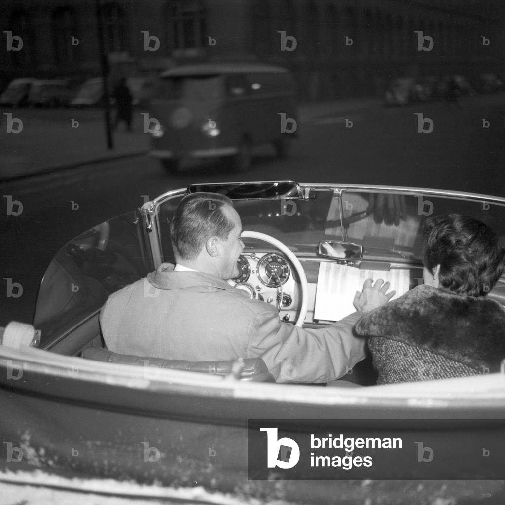 A couple driving throug hHamburg city centre in their Mercedes Benz convertible, 1955