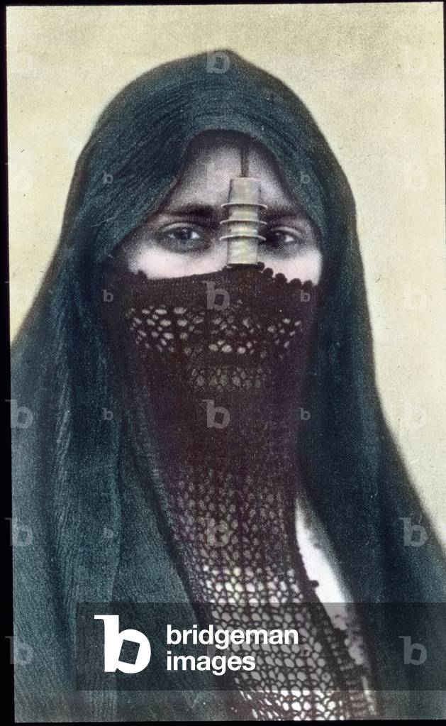 Egypt, portrait a woman with a face veil, image date: circa 1910. Carl Simon Archive