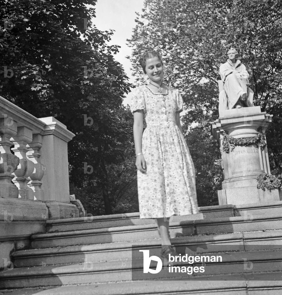 A young woman in front of a sculpture of Justus von Liebig, Germany 1930s (b/w photo)