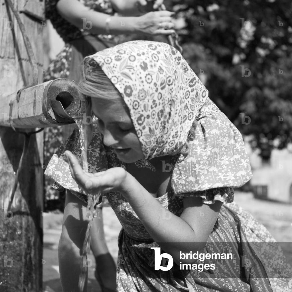 A young woman in front of a fountain at the Wachau area in Austria, Germany 1930s (b/w photo)
