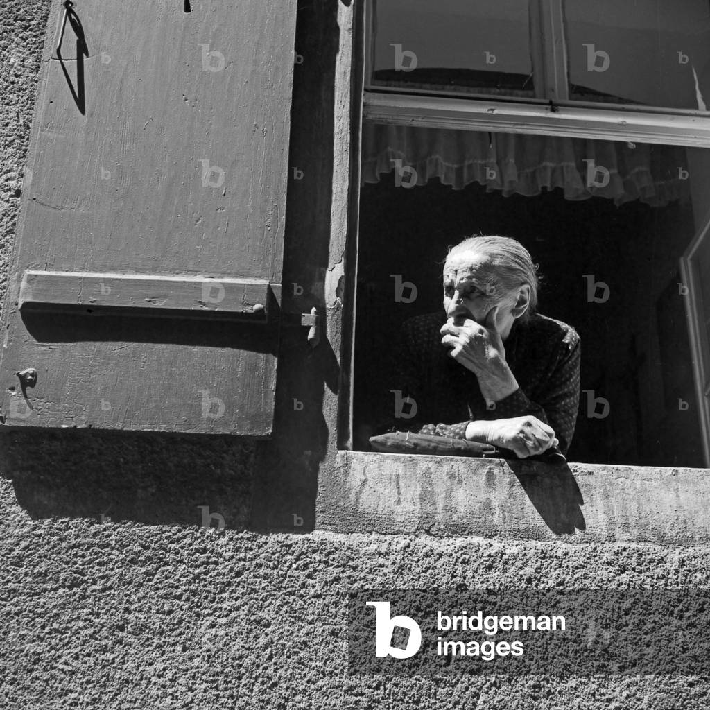 An old woman watching out of her window at Regensburg, Germany 1930s (b/w photo)