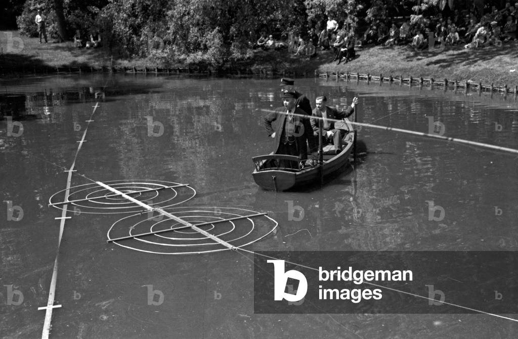 The fishermen have to hit these targets on the water at an angling contest, Germany 1930s (b/w photo)