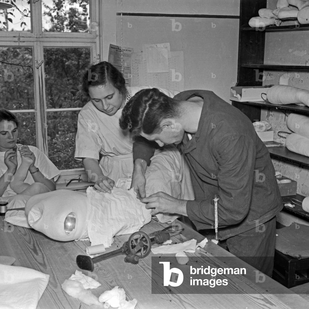 Staff members putting together one of the Kaethe Kruse display dummies, Germany 1930s (b/w photo)