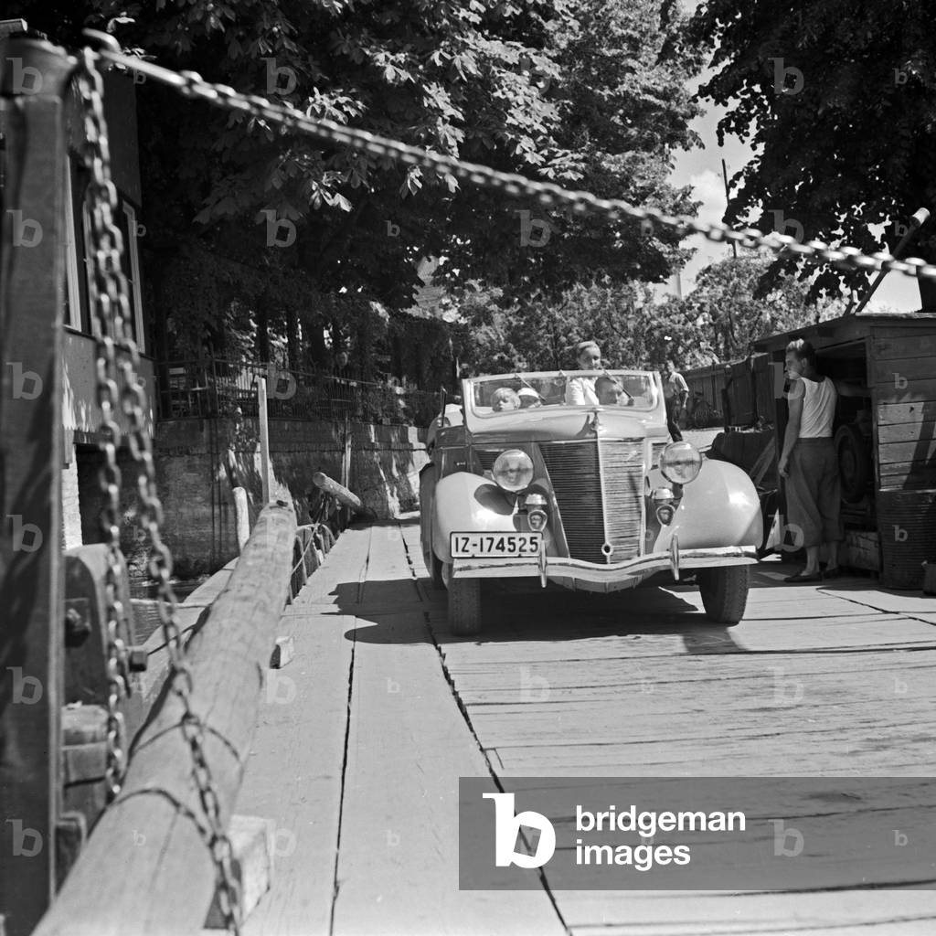 A family entering a ferryboat with their convertible, Germany 1930s (b/w photo)