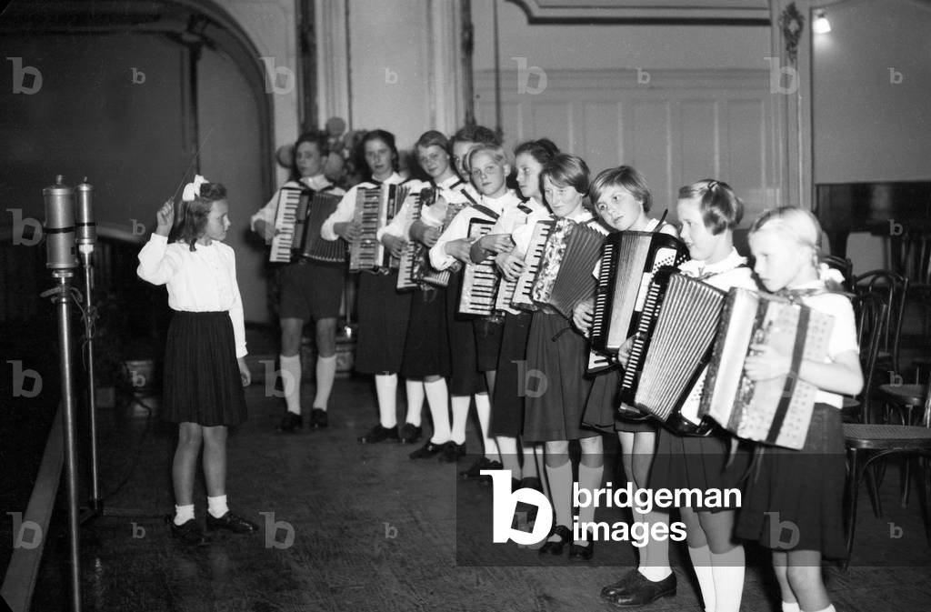 A little girl conducting a children's accordion orchestra, Hamburg 1954