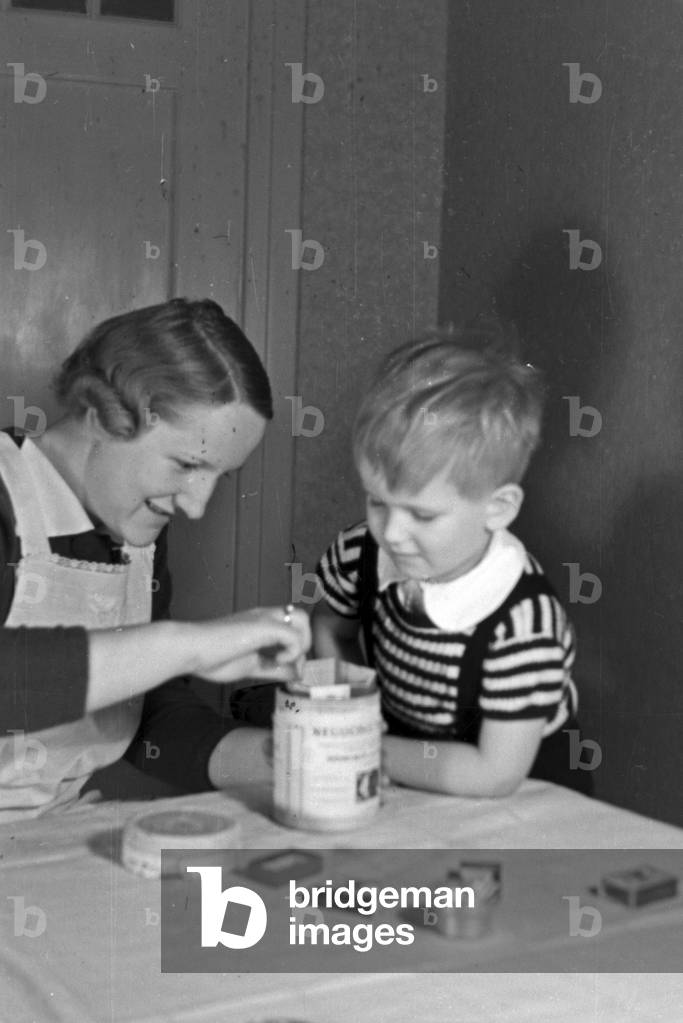 Mother and child doing handicrafts, Germany 1930s (b/w photo)
