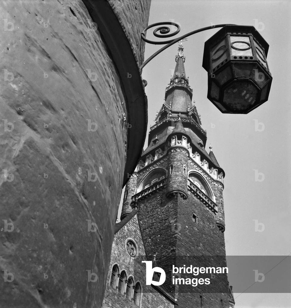 Aachen city hall tower with street light on a corner house at Aachen, Germany 1930s (b/w photo)