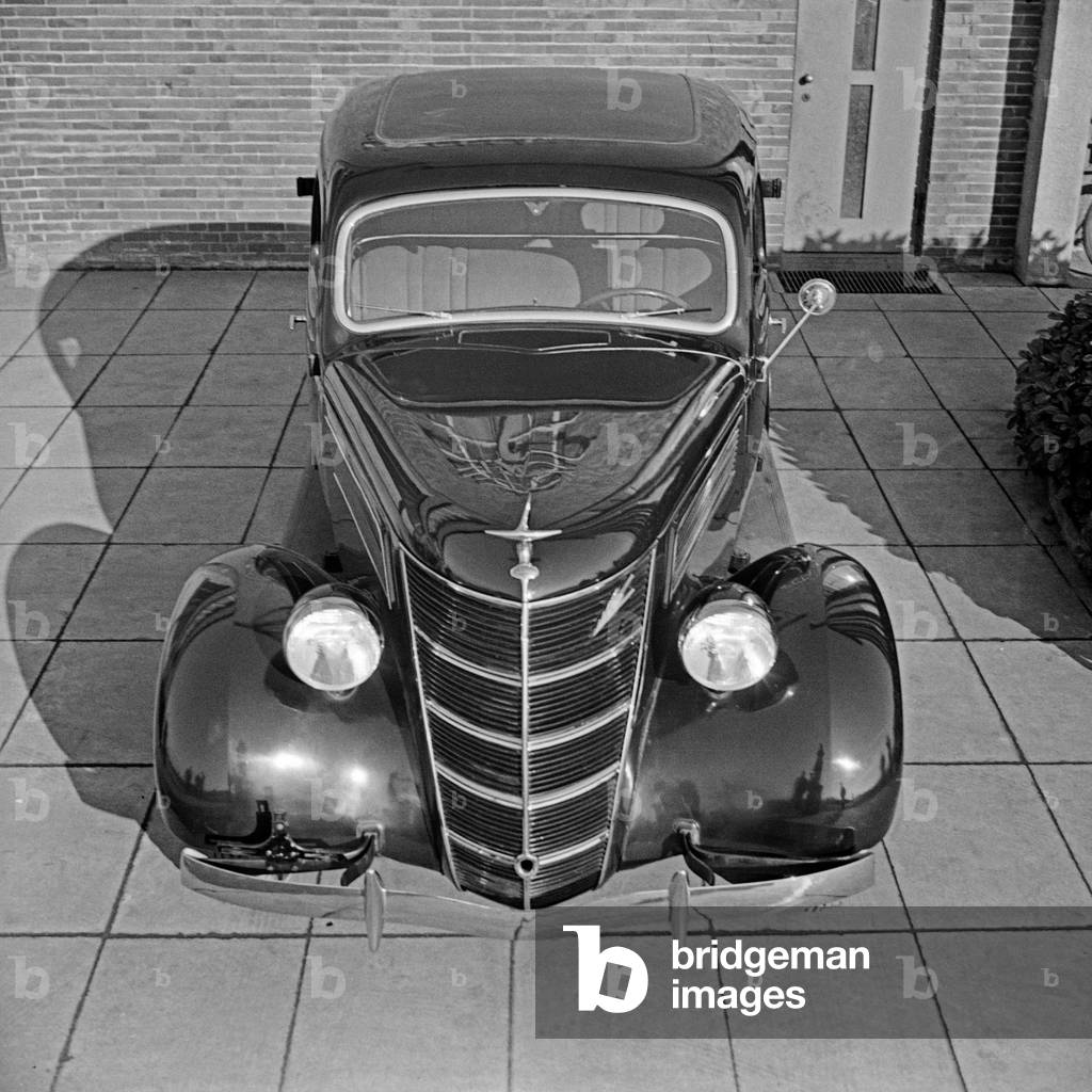 Front of a Ford V8 in front of the German Ford headquarters at Cologne, Germany 1930s (b/w photo)