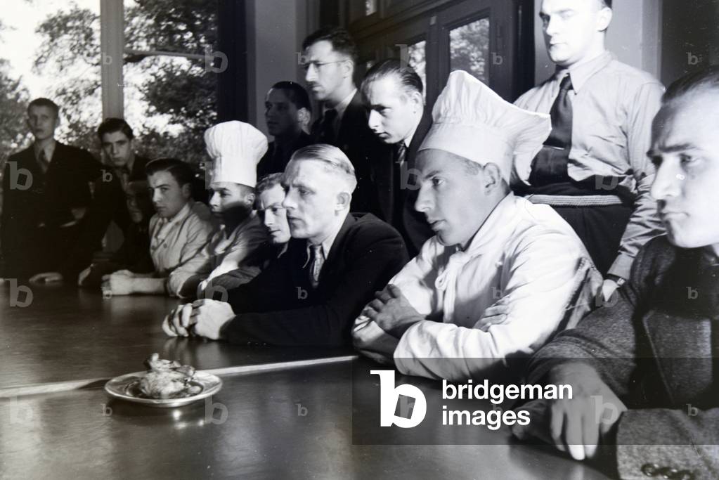 The highly concentrated trainees are listening to the explanations of the master chef during a seminar of the Reichskochschule, Germany 1930s (b/w photo)