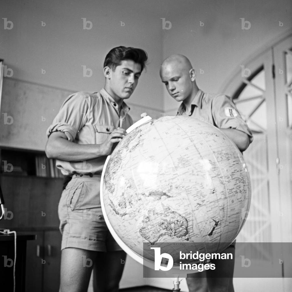 Pupils with a globe in a classroom at an educational quay of the navigation school Falkenstein at Hamburg Blankenese, Germany 1950s