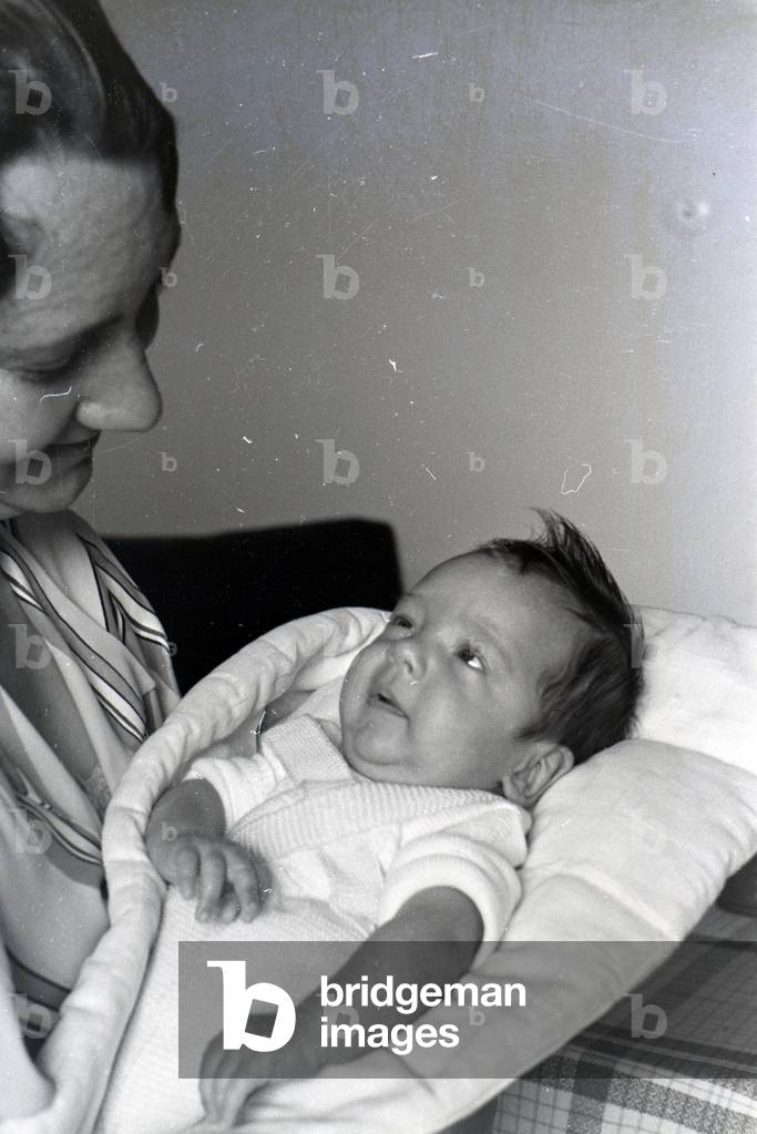 A woman holding a baby and smiling, Germany 1930s (b/w photo)