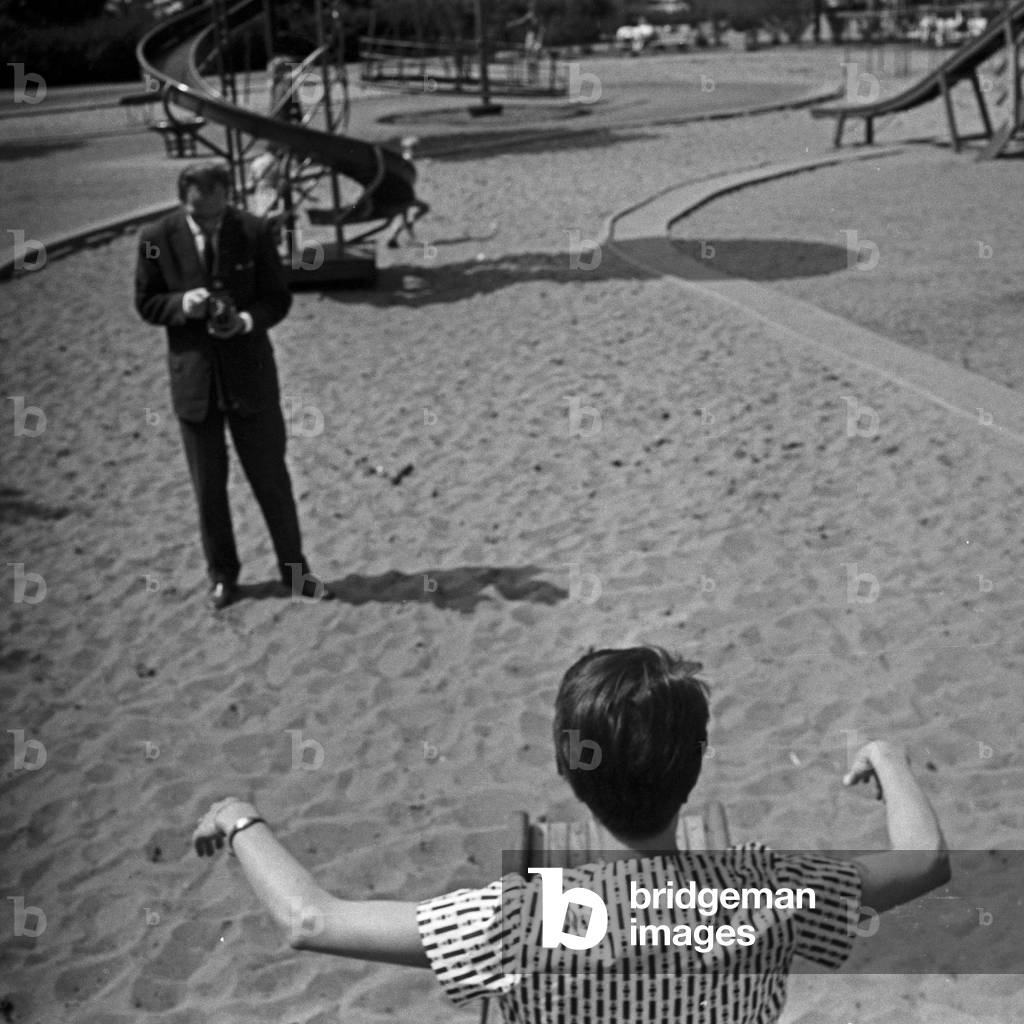 German television announcer Irene Koss on the chute of the playground at Planten un Blomen public gardens in Hamburg, Germany 1950s