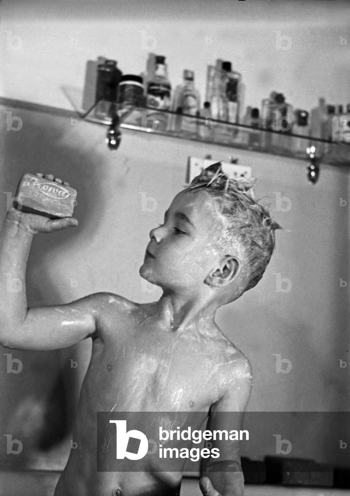 A bathing little boy presenting Kowa soap, a product of the Deutsche Fettsäurewerke and Maerkische Seifenindustrie company at Witten, Germany 1930s (b/w photo)