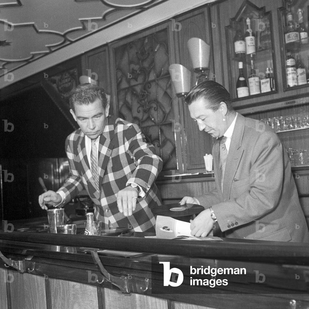 German entertainer and show presenter Peter Frankenfeld working together with the barkeeper of a hotel bar, Hamburg 1954