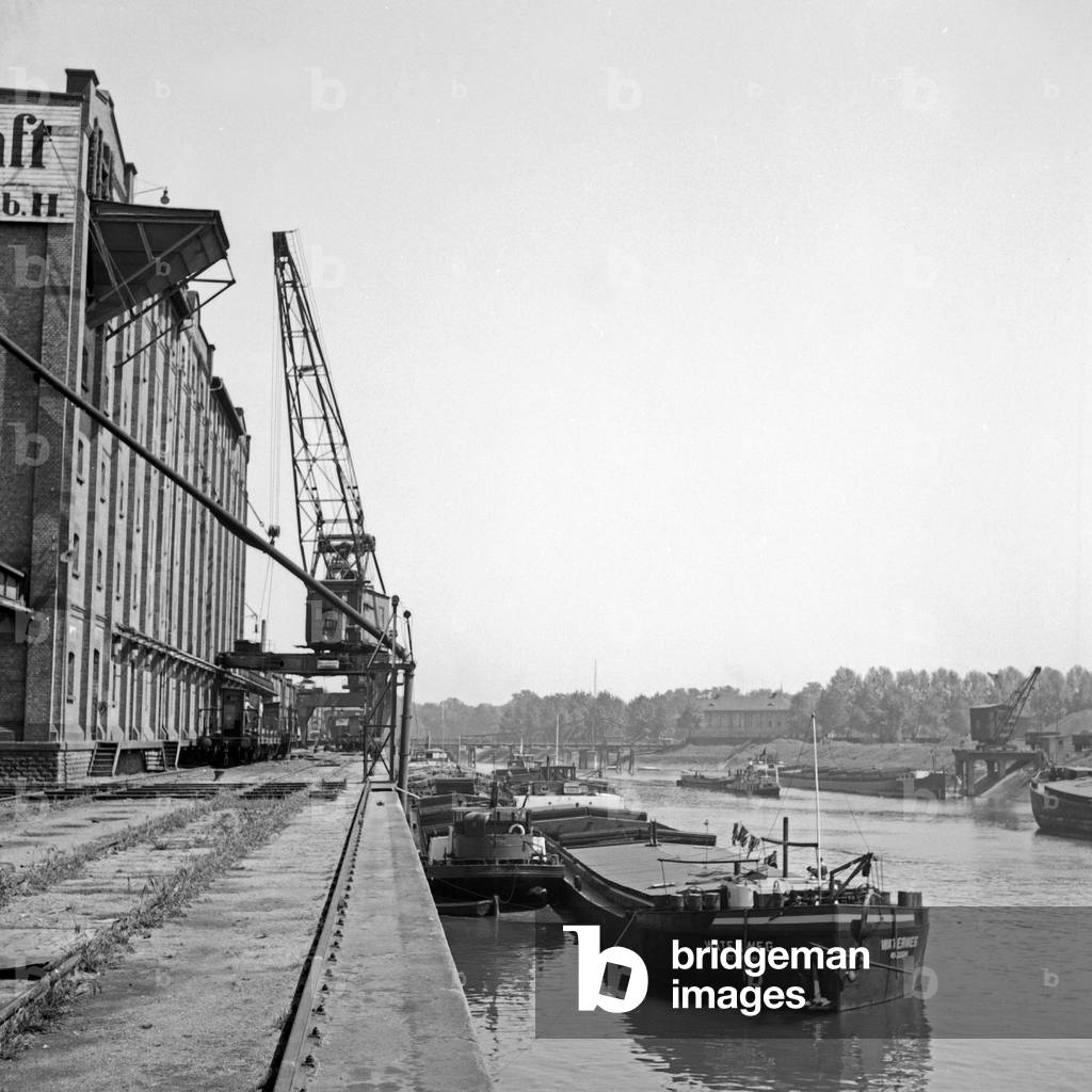 At the quay of the Bayerische Transportgesellschaft at Ludwigshafen harbor shop are loaded and unloaded, Germany 1930s (b/w photo)