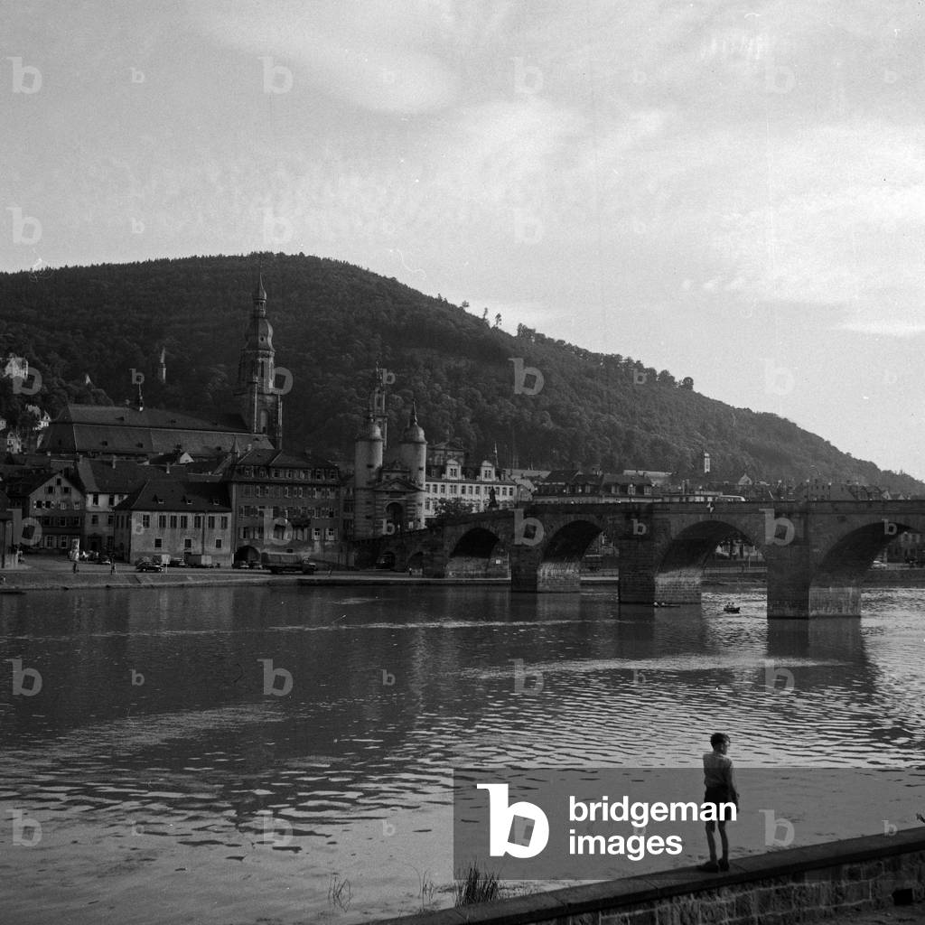 View to river Neckar, the old bridge and the Heiliggeistkirche church at Heidelberg, Germany 1950s
