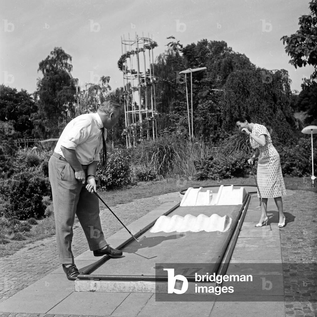 German television announcer Irene Koss playing crazy golf at Planten un Blomen public gardens in Hamburg, Germany 1950s