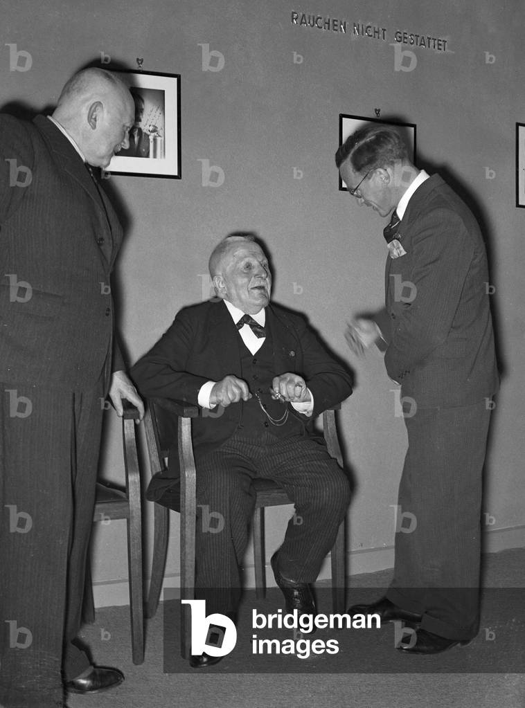 A music crew around a musician at the broadcasting building in Berlin, Germany 1930s (b/w photo)