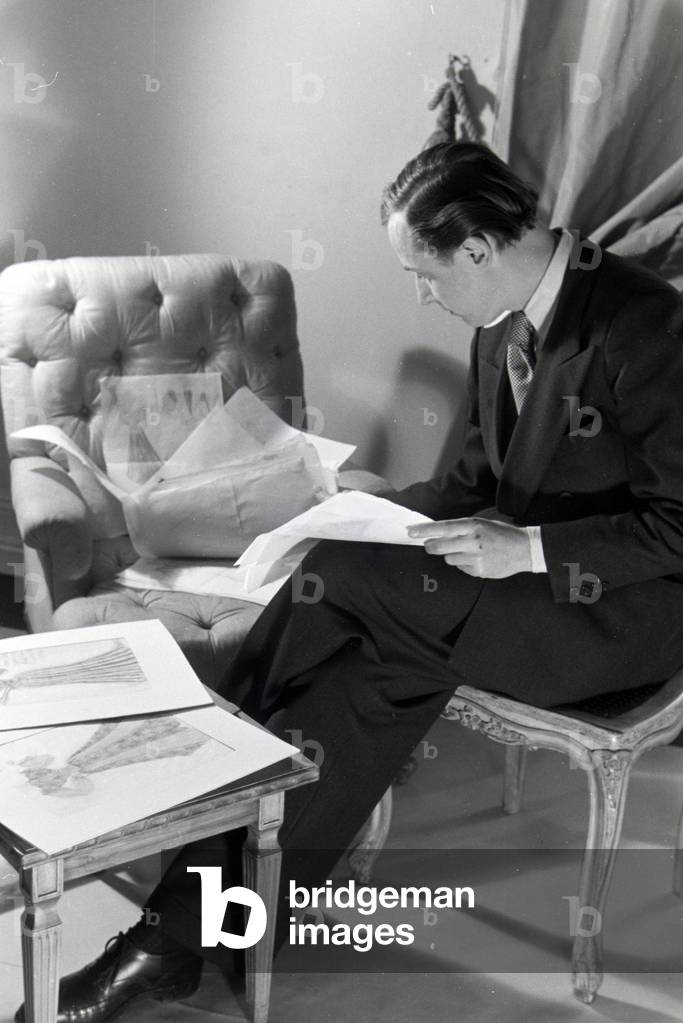 The fashion designer Heinz Schulze-Bibernell looking at his design sketches, Germany ca.1939 (b/w photo)