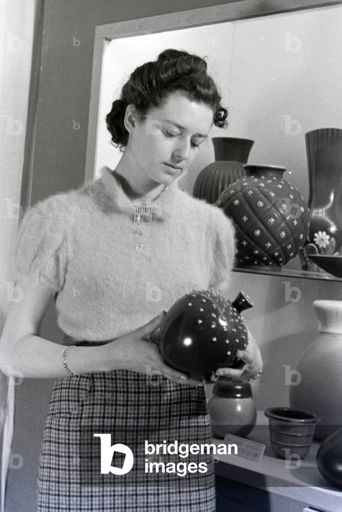 A visitor of the Leipziger Frühjahrsmesse in front of a stand of the porcelain factory Richard Ginori, Germany 1941 (b/w photo)