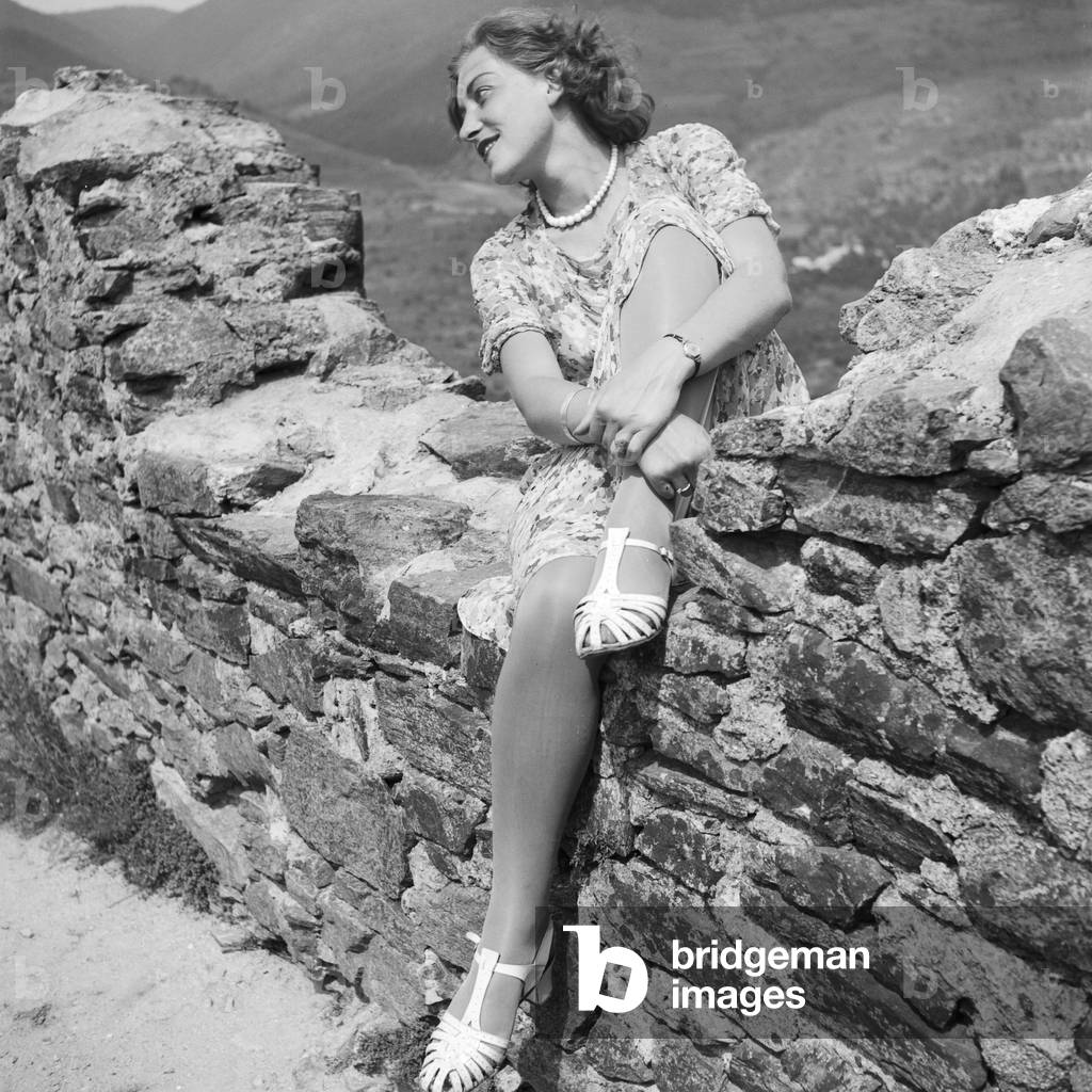 A young woman sitting in the remains of an old castle in the Wachau area in Austria, Germany 1930s (b/w photo)