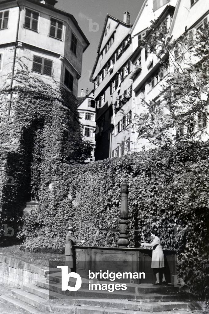 The water well with inscription on the patio of the Protestant church foundation, Tübingen, Germany 1930s (b/w photo)