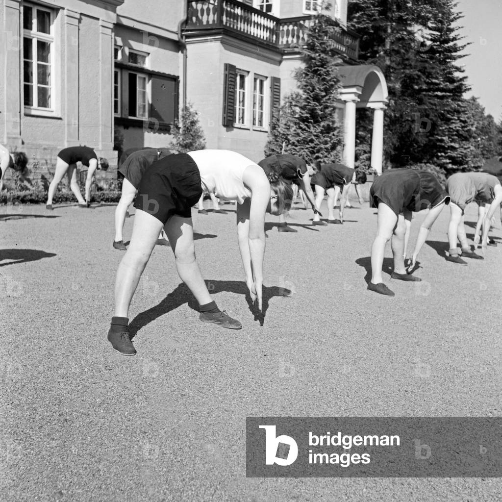 Women doing exercises in the morning at a mother and child recreation home at Tabarz, Thuringia, 1930s (b/w photo)