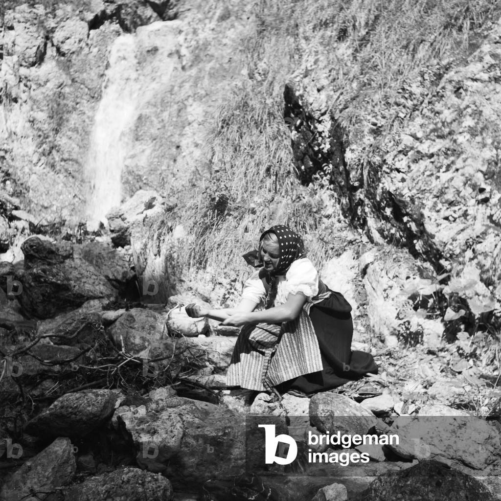 A young woman climbing on a mountain in the Wachau area in Austria, Germany 1930s (b/w photo)