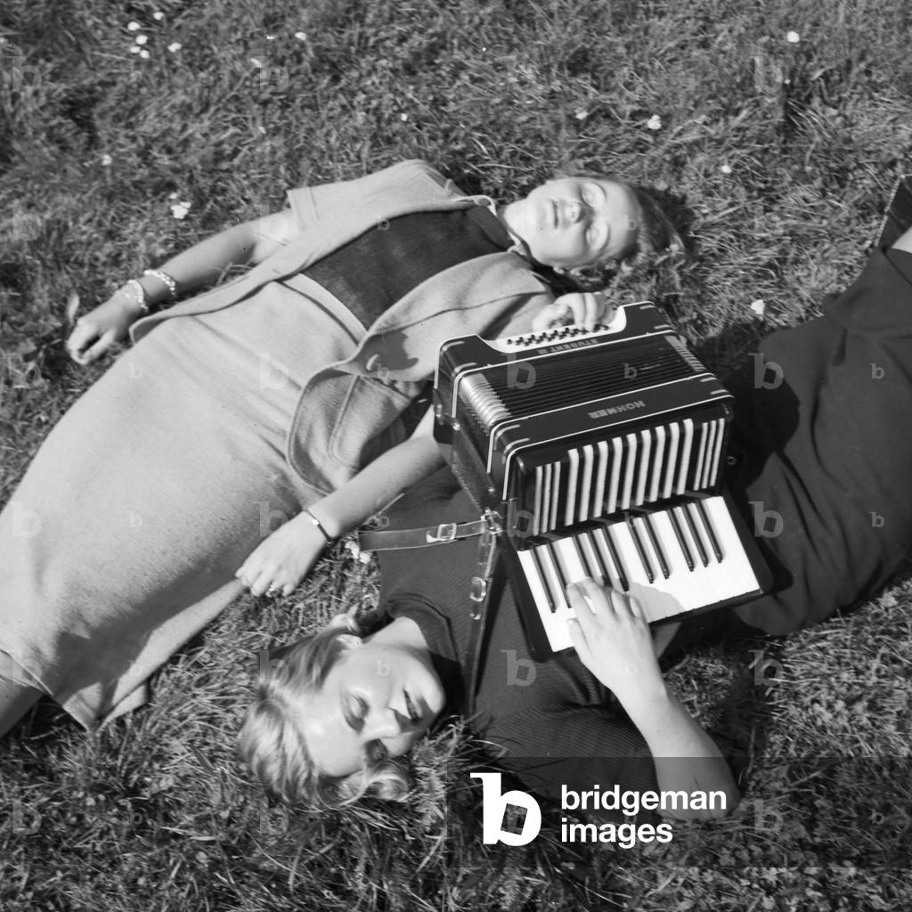 Two women playing music with an accordion, Germany 1930s (b/w photo)