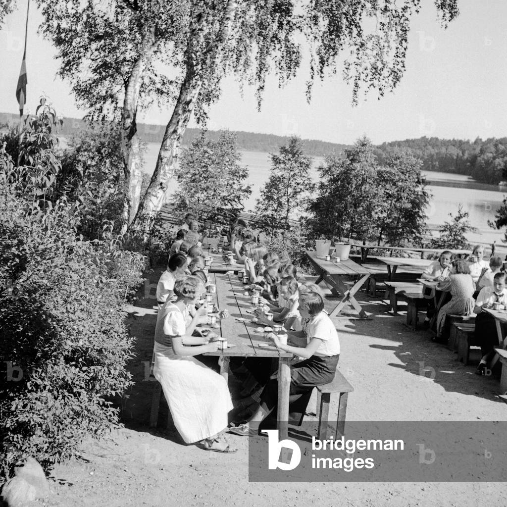 Having dinner at the leisure camp of the Deutsche Arbeitsfront at Altenhof, Werbellinsee, Brandenburg, 1930s (b/w photo)