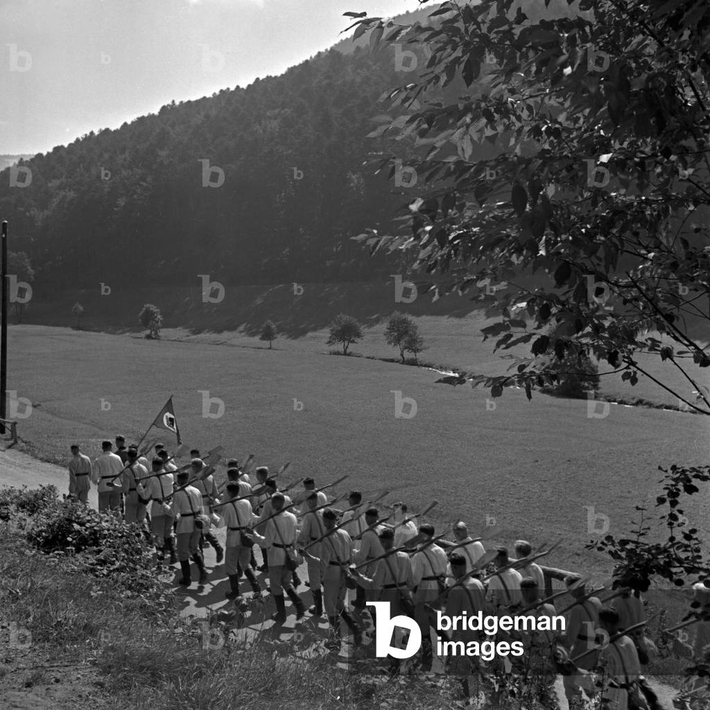 A platoon of the Reichsarbeitsdienst marching to its destination near Herrenalb in Black Forest, Germany 1930s (b/w photo)