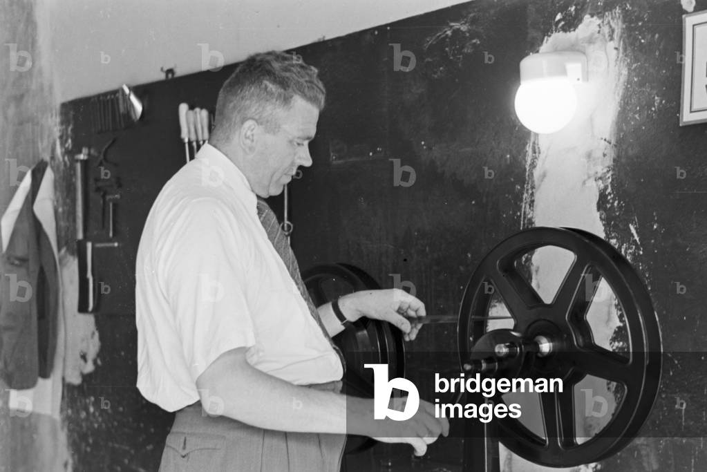 Staff member of a meteorological office inserting a film, Germany 1930s (b/w photo)