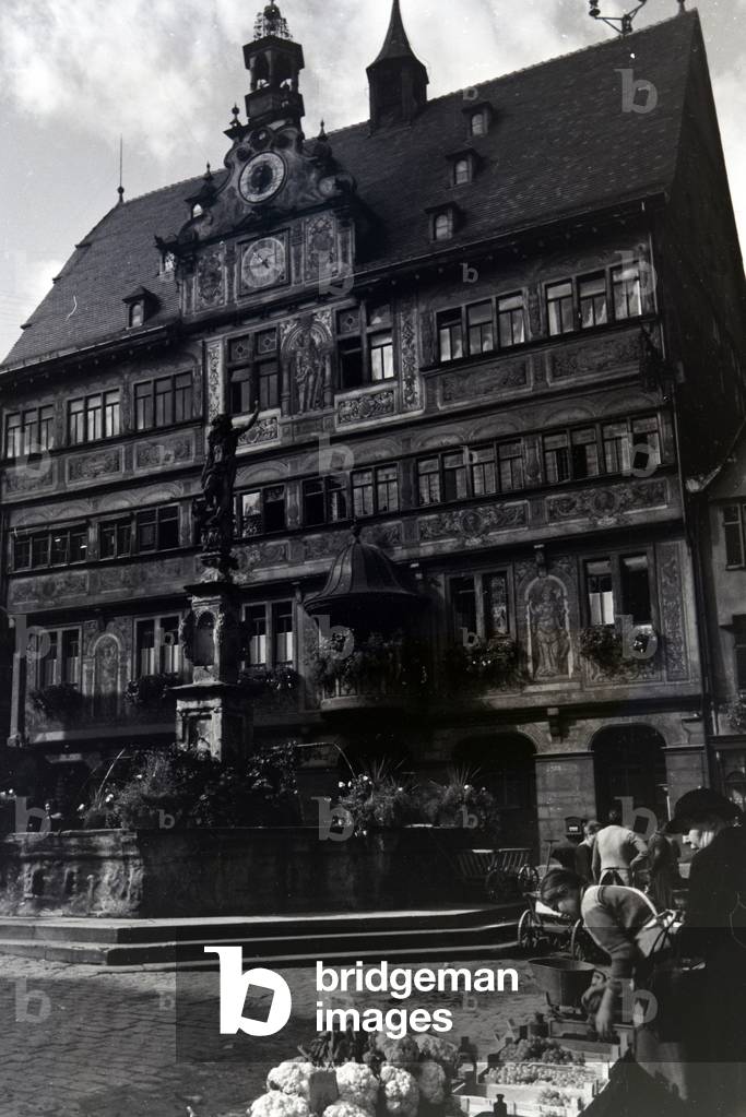 The vegetable market in front of the city hall with the astronomical clock on the market square in Tübingen, Germany 1930s (b/w photo)