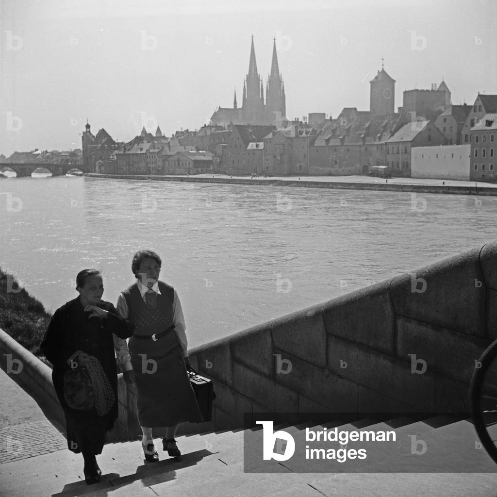 Two women on the stairs to one of the bridges over river Danube at Regensburg, Germany 1930s (b/w photo)