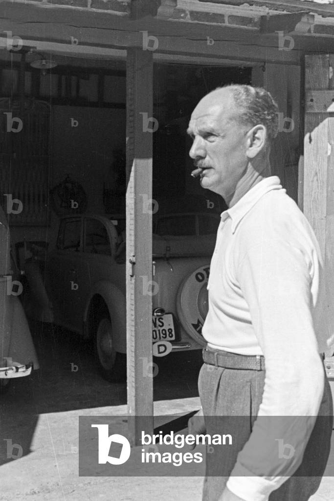 A man in front of a garage on his vacation at the Baltic Sea, Germany 1930s (b/w photo)