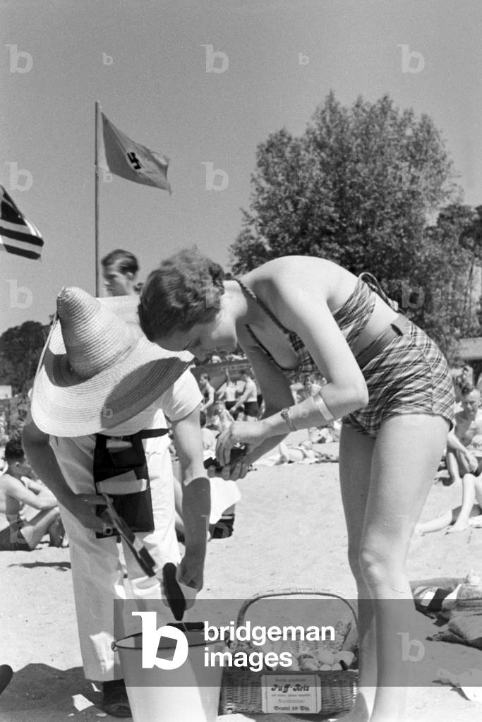 Swimming beauty buying an ice cream at lake Wannsee lido in Berlin, Germany 1930s (b/w photo)