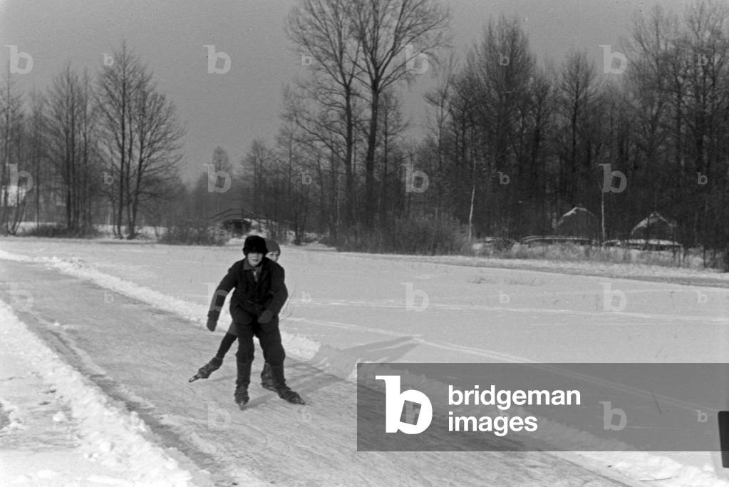 Two boys skating on a frozen lake at Spreewald area, Germany 1930s (b/w photo)