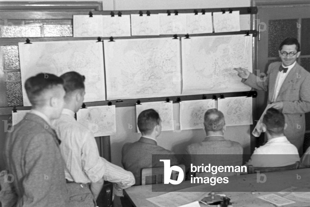 Staff member of a meteorological office working with maps, Germany 1930s (b/w photo)