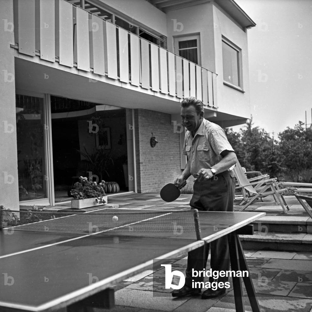 Peter Frankenfeld playing ping-pong at the terrace of his home at Wedel near Hamburg, Germany 1950s
