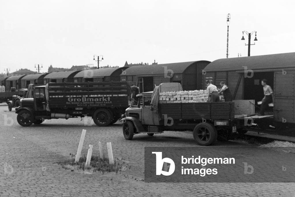 Strawberries are taken from vegetable vendors at the station in Berlin, Germany 1930s (b/w photo)