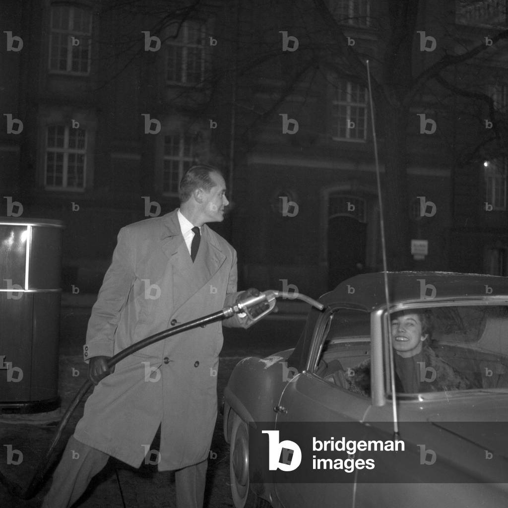 German jazz pinaist and composer Fritz Schulz - Reichel with his Mercedes Benz 190 SL convertible at a petrol station, Hamburg 1955