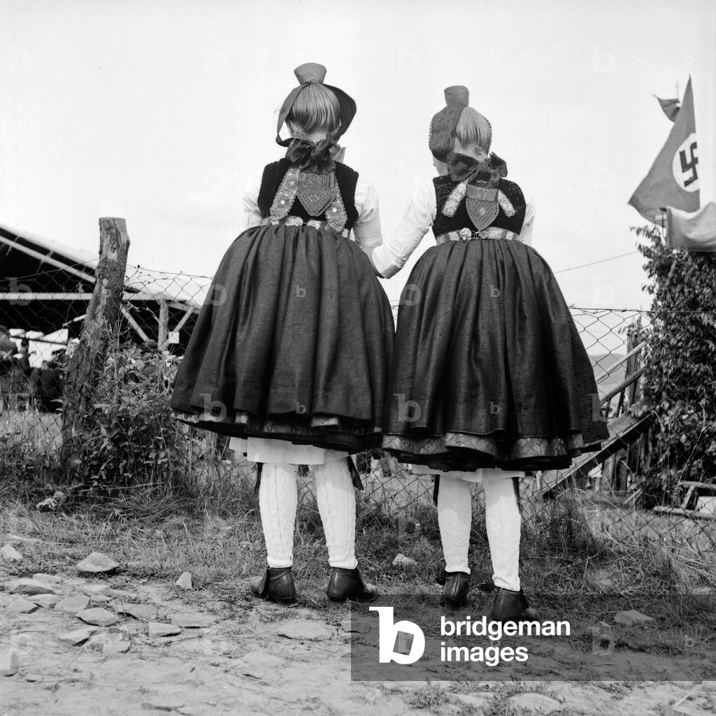 Rear view of two girls wearing the Western Hessian array of the Schwalm area, Germany 1930s (b/w photo)