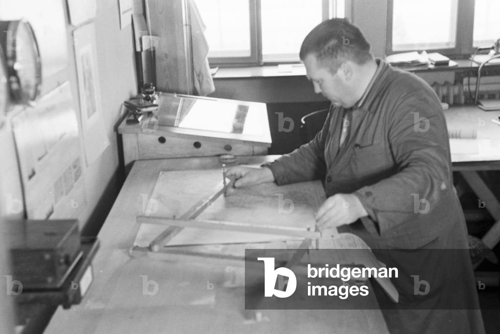 Staff member of a meteorological office working with maps, Germany 1930s (b/w photo)