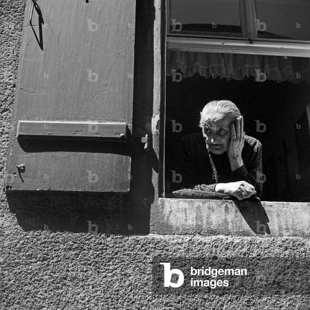 An old woman watching out of her window at Regensburg, Germany 1930s (b/w photo)