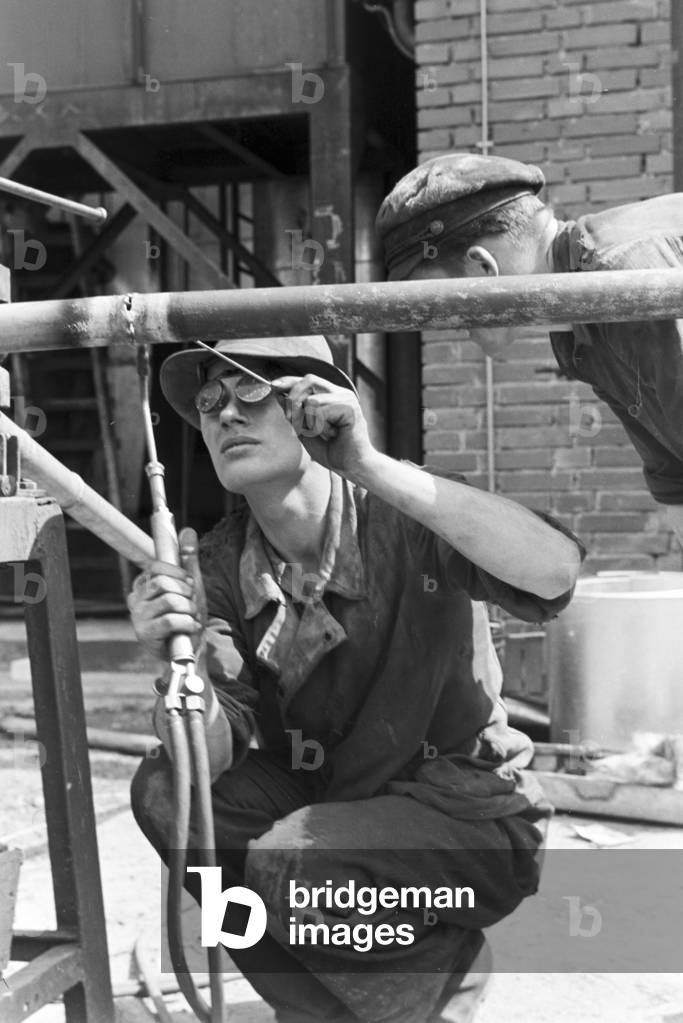 A welder bonding different components, Witten, Germany 1930s (b/w photo)