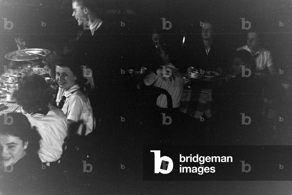 A figureskating group of the Hitler Youth wearing uniforms of the HJ and BDM during dinner after a training, Germany 1930s
