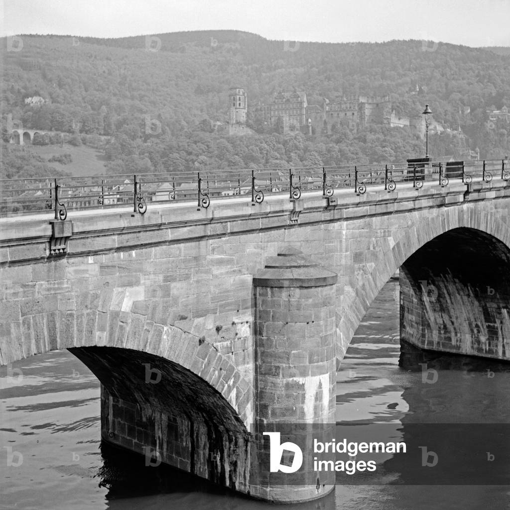 The old bidge over the river Neckar with view to Heidelberg castle, Germany 1930s (b/w photo)
